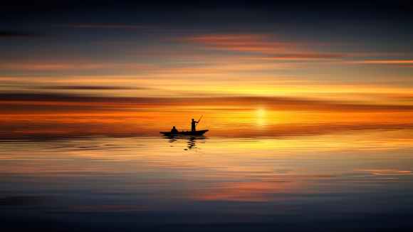 photo of people on rowboat during sunset